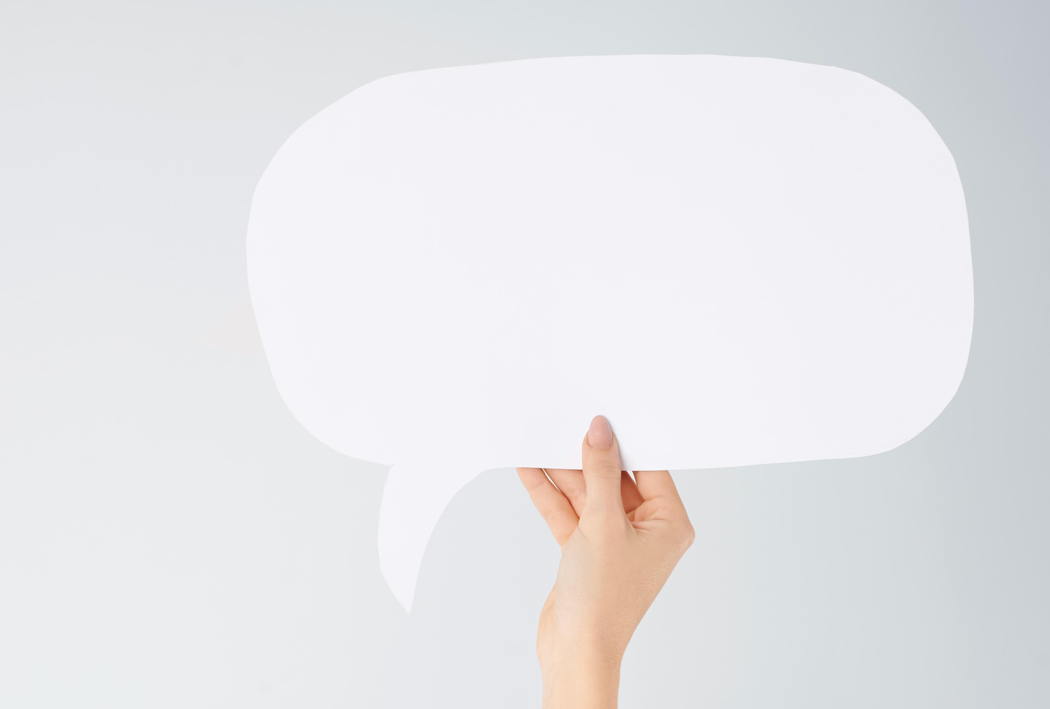 Hånd holder snakkeboble